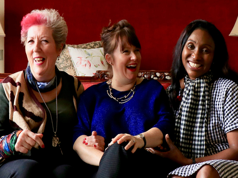 A group of women sat down smiling