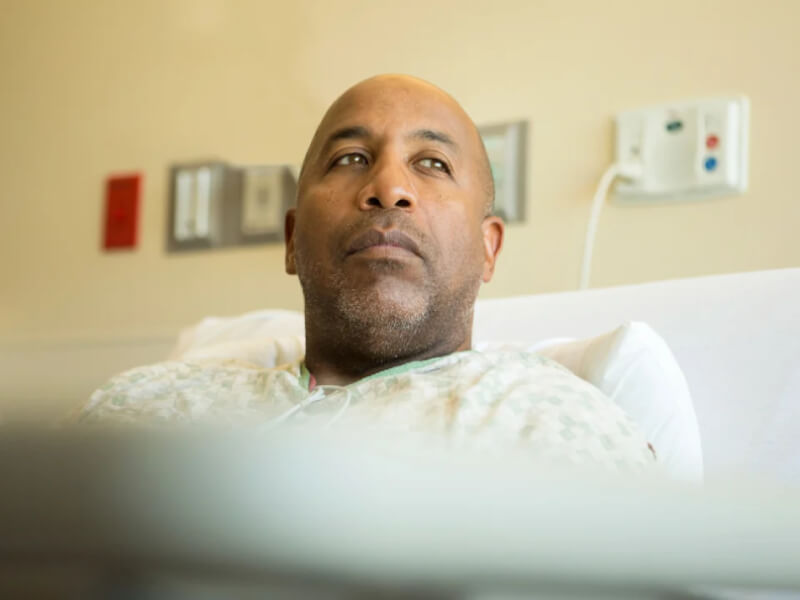 A man laying down on a hospital bed
