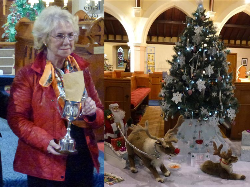 Eileen holding her trophy, next to her is her winning decorated Christmas tree