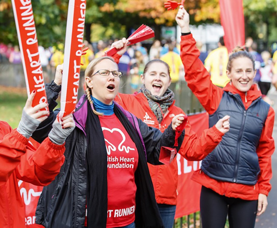 Three volunteers cheering at an event