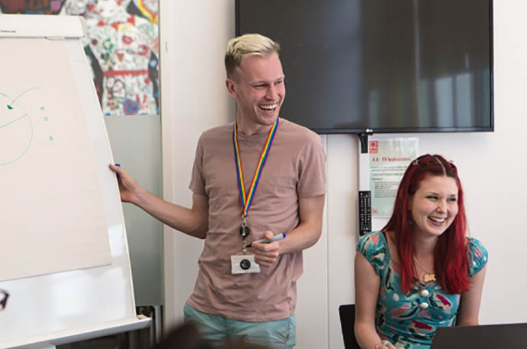 Two BHF employees smiling during a meeting at work