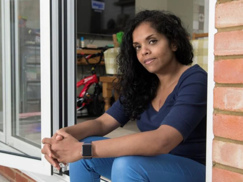 A woman sitting by an open window