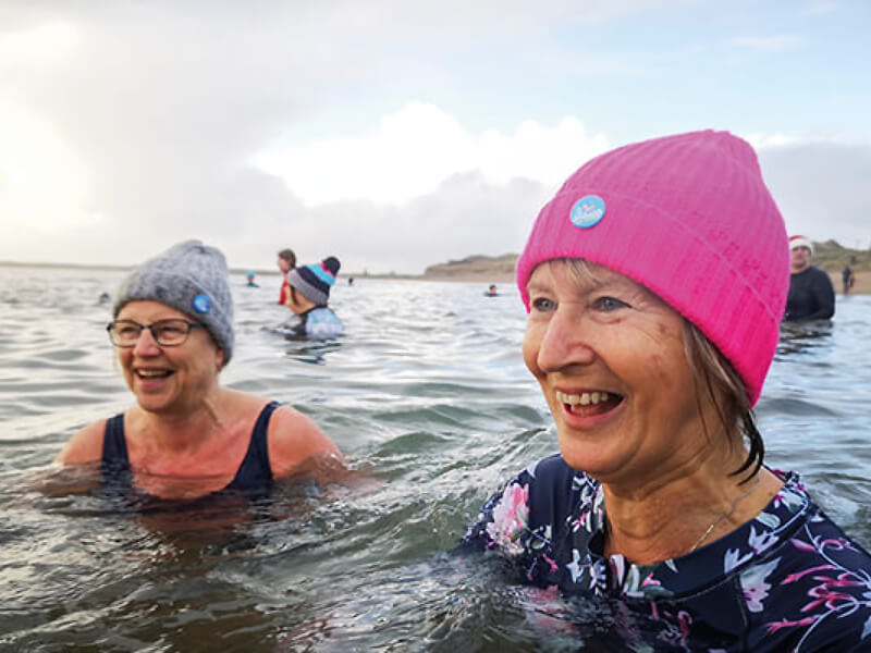 Two women swimming together and smiling