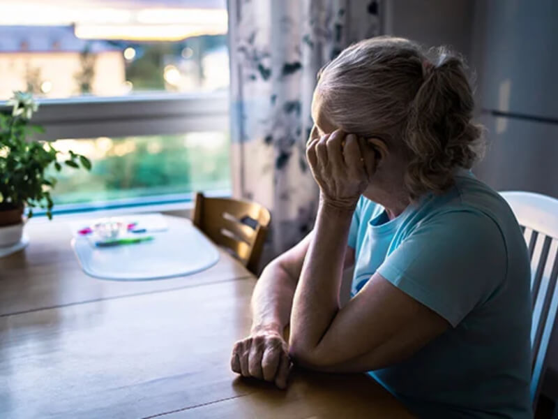 A woman sat by a table looking out a window