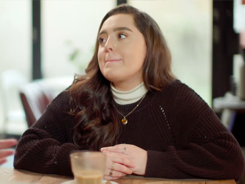 A woman sat on a table looking to her side