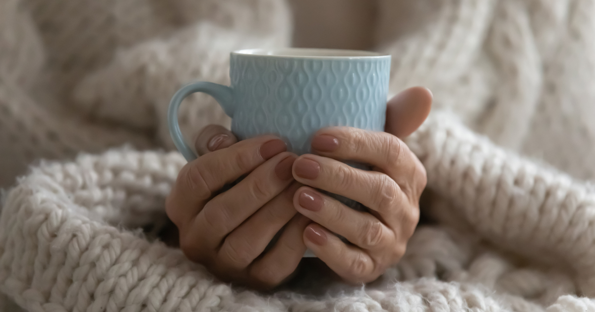 Female hands cupping a mug of tea