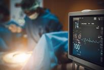 Surgeons performing an operation in blue scrubs. 