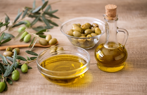 Image of a bottle and bowl of olive oil and a bowl of olives