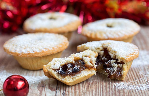 Mince pies surrounded by baubles and tinsel