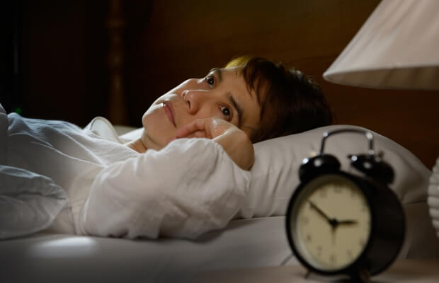 A woman struggling to sleep