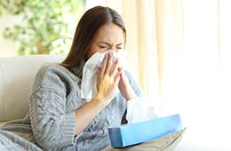 Woman with the flu, sneezing