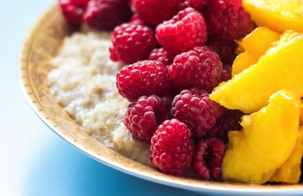 Porridge topped with peaches and raspberries