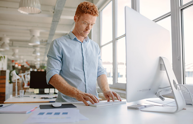 A male working at a standing desk 