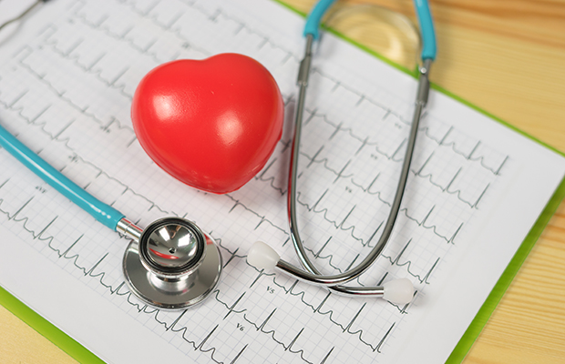 A heart and stethoscope resting on an ECG of the heart