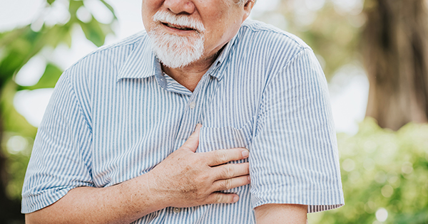 Elderly man with angina clutching his chest