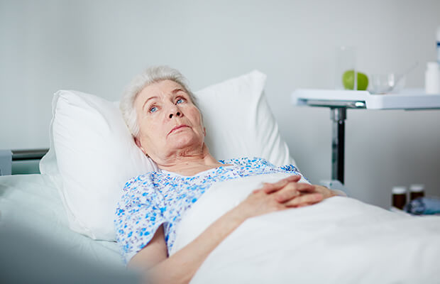 Elderly lady lying in a hospital bed having hallucinations