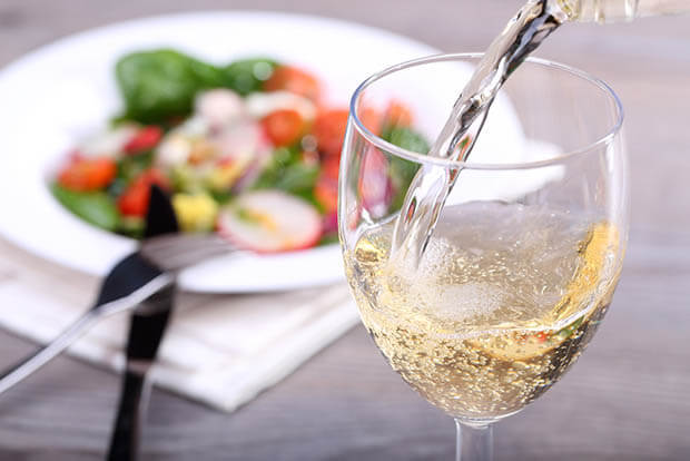 Glass of white wine being poured