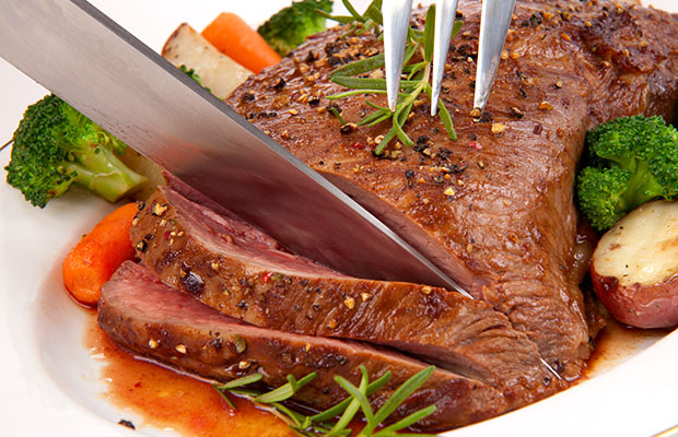 Red meat on a plate being cut
