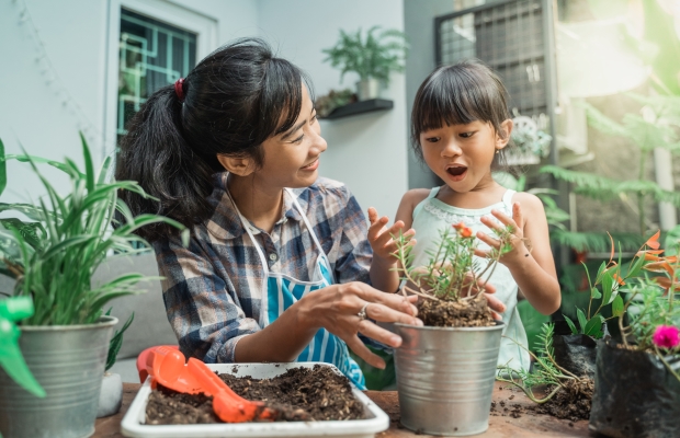 mother and daughter planting flower in pot