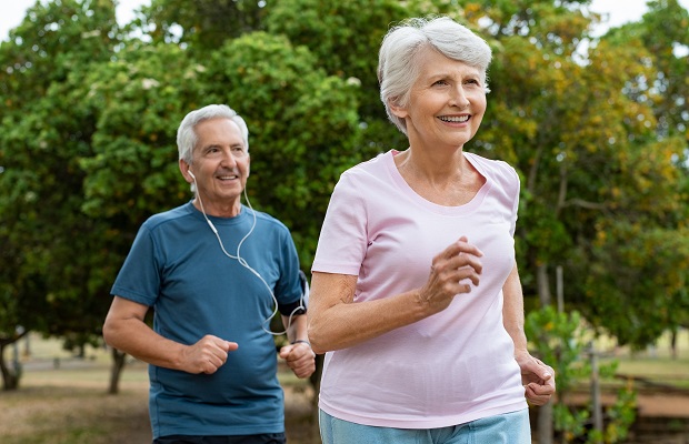A senior man and woman jogging in a park