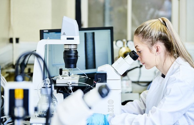 A researcher looking through a microscope