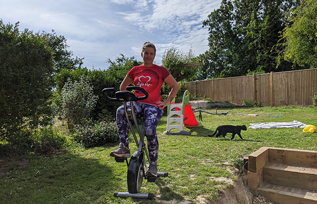 Mel Bucknell on an exercise bike in the garden