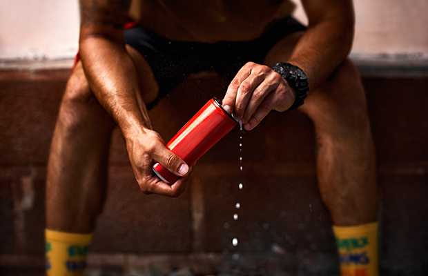 Man holding a red aluminium can of energy drink