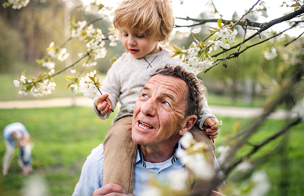 Senior man with child on shoulders