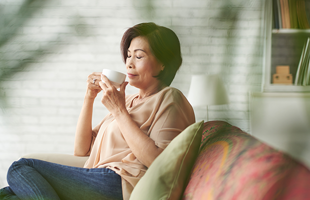 Woman drinking coffee on sofa