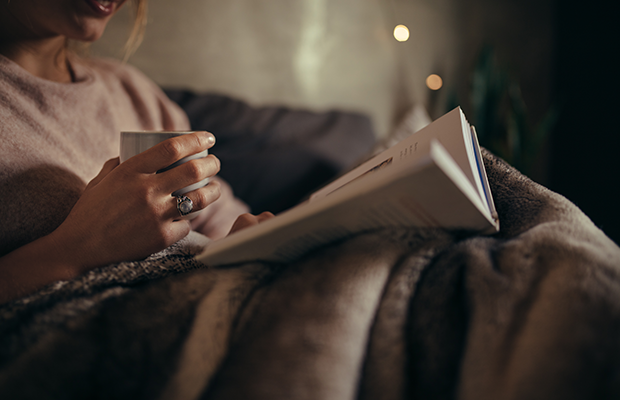 Woman reading with a hot drink