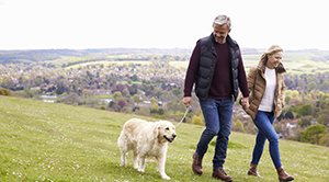 Mature couple walking dog