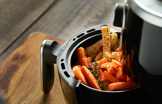 image of an air fryer containing cooked sweet potatoes
