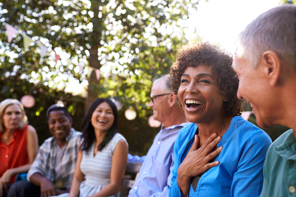 A group socialise and laugh outside