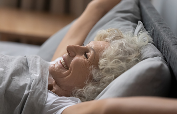 Woman waking up in bed appearing refreshed