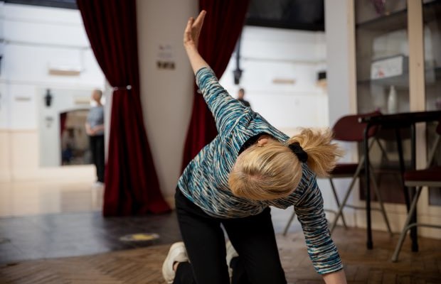 Katharine Holmes does a yoga pose in the dance hall where she practices ballroom dancing.