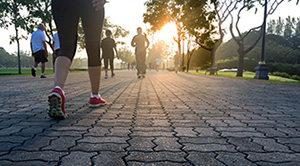 People dressed in sports gear and trainers walking on a cobbled pavement