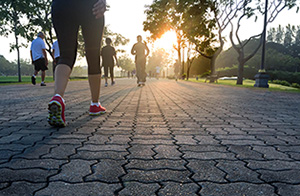 People dressed in sports gear and trainers walking on a cobbled pavement