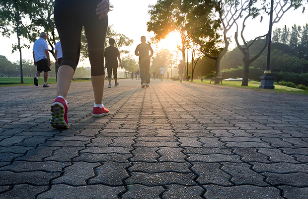People dressed in sports gear and trainers walking on a cobbled pavement