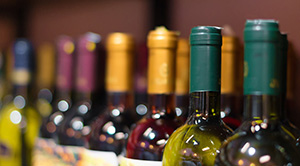 A row of red wine bottles on a shelf