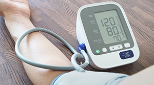 Digital blood pressure monitor showing "120 over 80"