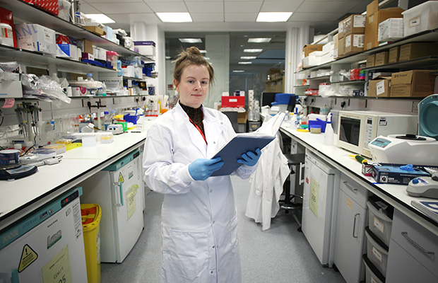 Dr Karla O'Neill holding a clipboard in the laboratory.