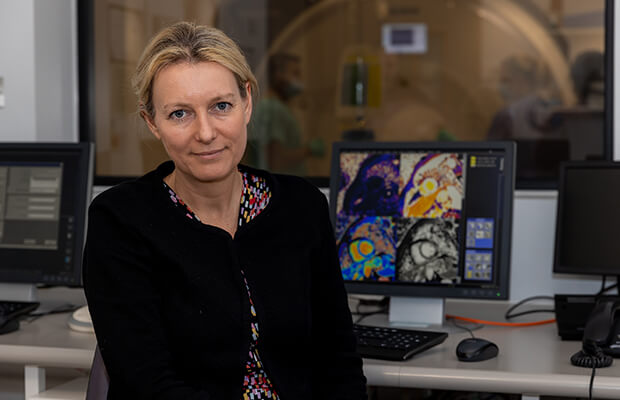 Charlotte Manisty sits in front of a computer screen of MRI scan images