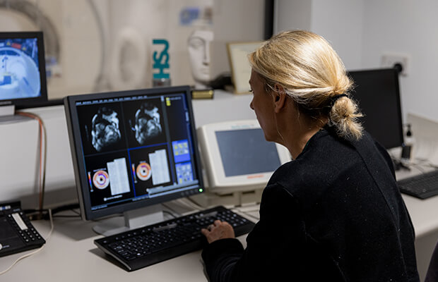 Charlotte Manisty looks at MRI scan images on a computer screen.