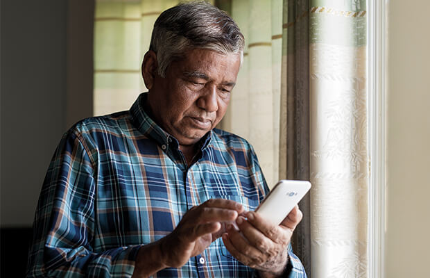 A person looks at the mobile phone in their hands