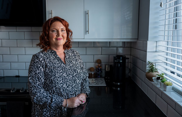 Rebecca standing in her kitchen with a smile