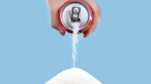 A can is being poured with white sugar coming out, creating a mound of sugar