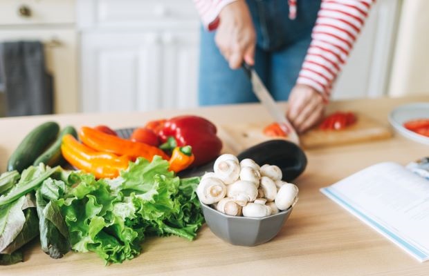 A person chops some whole vegetables.