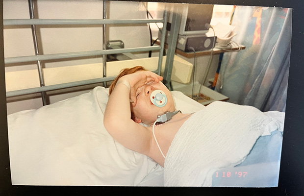 Kieran Cooper lying in a hospital bed as a toddler