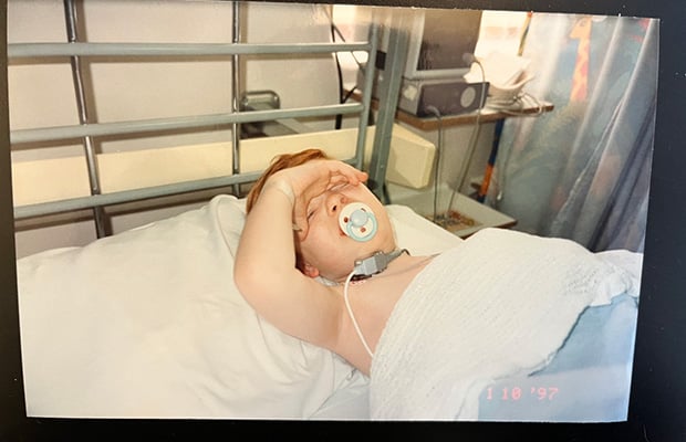 Kieran Cooper lying in a hospital bed as a toddler
