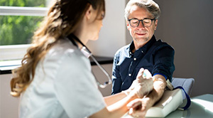 A healthcare professional takes a man's blood.